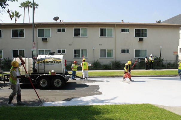 Photo des services publics de la ville de Los Angeles (Californie) en train de recouvrir des routes de bitume d'un revêtement blanc pour lutter contre les îlots de chaleur